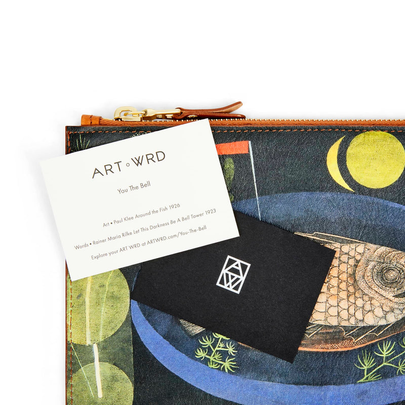 ART WRD artist and writer information cards laying on top of a unique bag with surrealist fish art by Paul Klee.