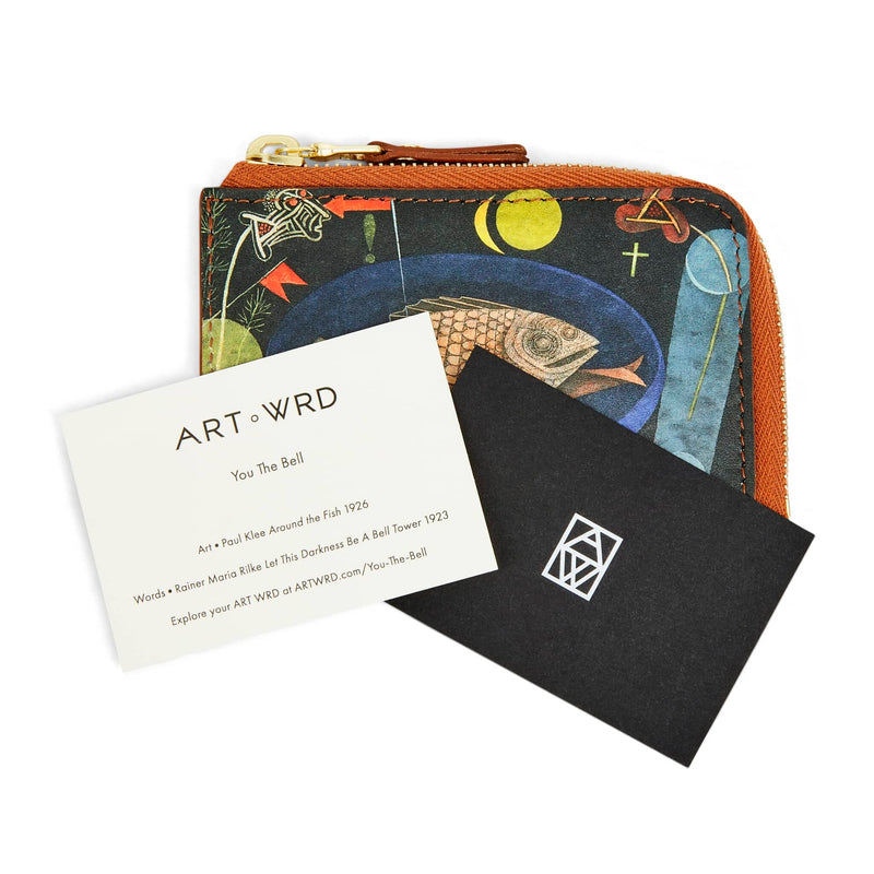ART WRD artist and writer information cards laying on top of an unusual purse with a fish art print by Paul Klee.