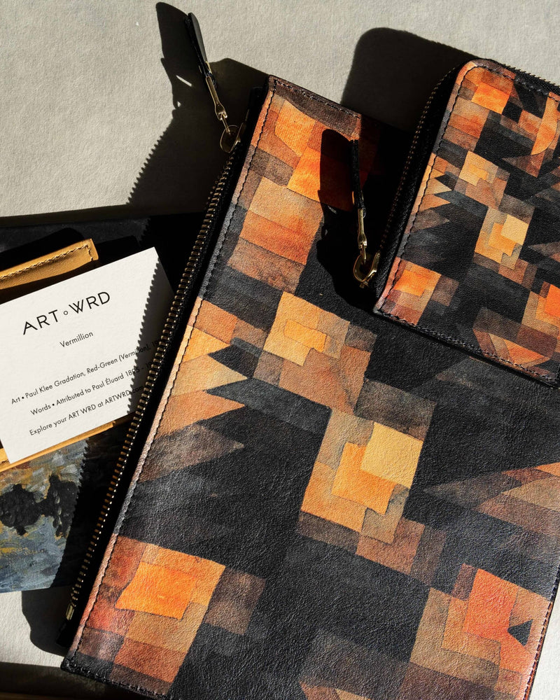 A cool unique wallet purse with Paul Klee art laid on a matching leather pouch bag.
