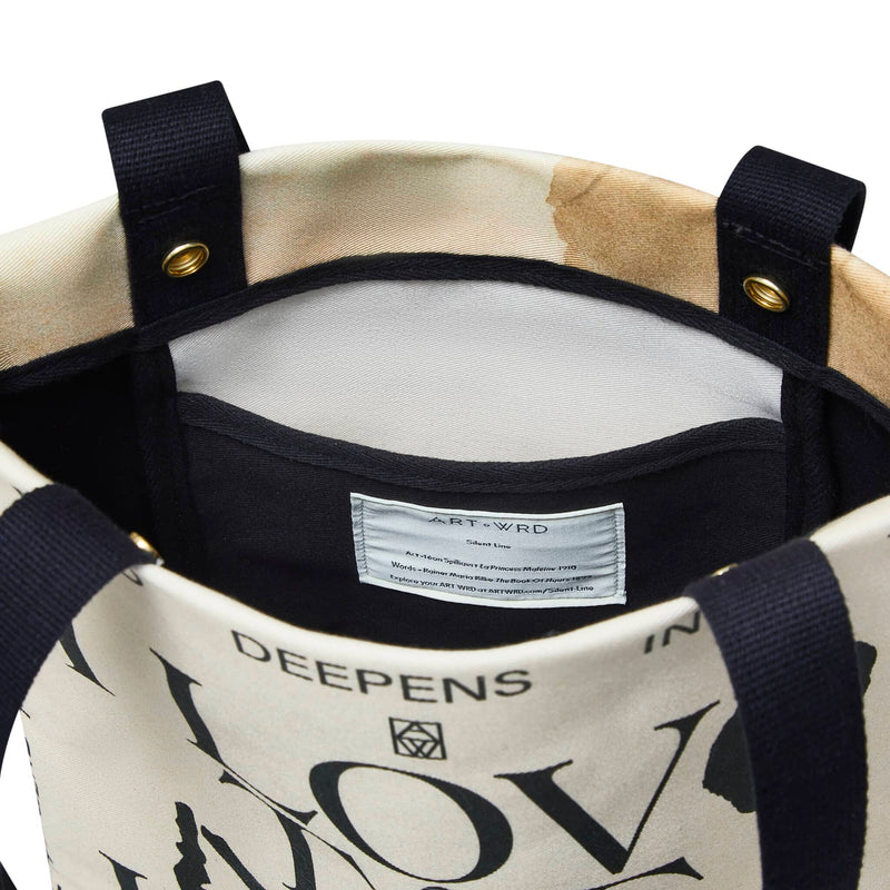 Unique art tote bag inside view. Double poppers, a drop pocket and the information label are visible.